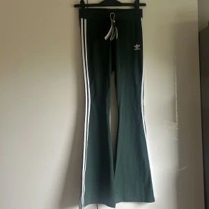 Green flared Adidas pants - Mörkgröna utsvängda byxor från Adidas. Sjukt coola och snygga! Tyvärr aldrig kommit till användning, så de är i nyskick med prislappen kvar.