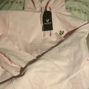 Ljusrosa hoodie från Lyle & Scott - Säljer en stilren ljusrosa hoodie från Lyle & Scott. Den har en klassisk design med en liten logotyp på bröstet och en justerbar huva. Perfekt för en avslappnad look.      Köpte den för 900kr !!  Skick 10/10(helt ny) ✅