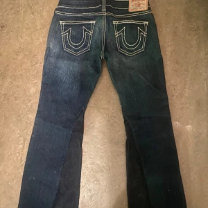 Mörkblå True Religion jeans - Mörkblå lågmidjade bootcut true religion jeans dom är avklippta där nere så dom kan va lite korta för vissa