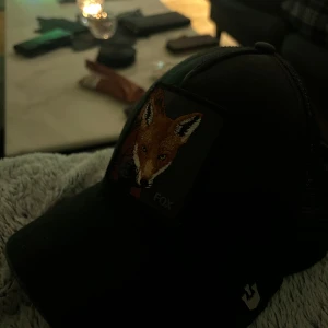  Goorin Bros keps  - Snygg svart keps från Goorin Bros med ett broderat rävmotiv på framsidan. Kepsen har en klassisk design med nätpaneler baktill för ventilation. Perfekt som en present/gåva använd ett fåtal gånger! (Pris kan diskuteras)