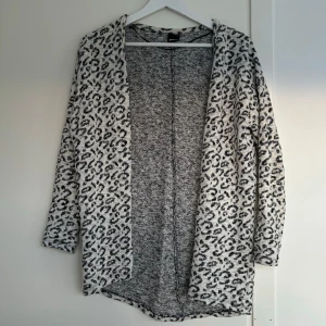 Kofta i leopardmönster - Fin kofta. Grått glittrigt leopard mönster. Använd men fortfarande i bra skick.