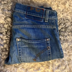 Dondup jeans - Snygga blå dondup jeans med slitningar och en cool, avslappnad look. De har en klassisk femficksdesign och dragkedja. Perfekta för en casual stil. Vid frågor, kontakta mig!