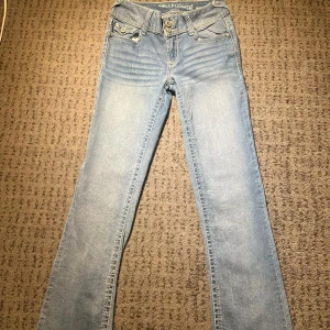 Ljusblå jeans från Wallflower - Snygga ljusblå jeans från Wallflower med broderade detaljer på bakfickorna. De är bootcut. Midja rakt över: 36cm. Lår: 25cm. Innerben: 81cm