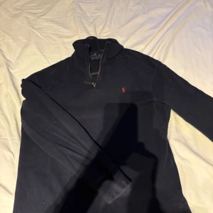 Mörkblå Ralph Lauren halfzip - Säljer denna mörkblåa Ralph lauren zip i storlek S! Den är i bra skick ä, runt 7,5/10!
