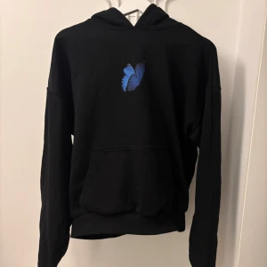 Svart hoodie av Upscale by Mister Tee - Skitsnygg svart hoodie av Upscale by Mister Tee. Stort tryck på ryggen och en liten fjäril på bröstet. Endast använd ett fåtal gånger och fortfarande i nyskick. Nypris 699. Hör av dig vid frågor och funderingar. Priset går att diskutera!