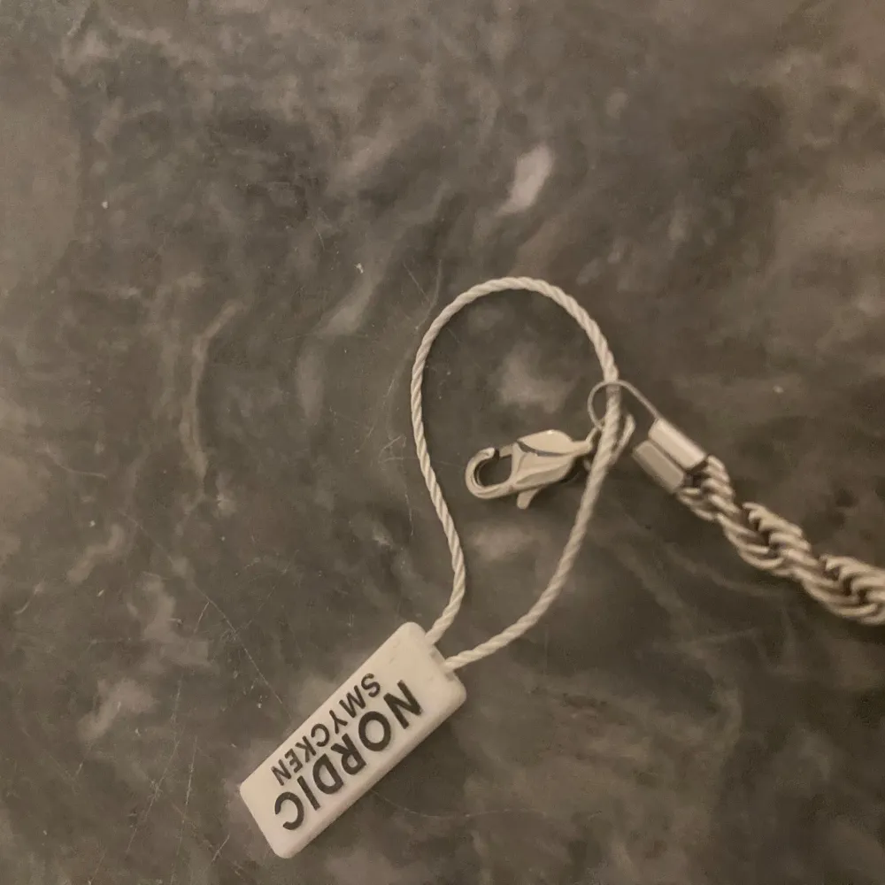 Cordell kedja 5mm 60cm. Cordell Armband 5mm 22cm. Säljer den för att jag har råkat beställa 2 styckna. Orörd och du får både Cordell kedja och armband samt påse med där du kan ha din kedja och armband. Den är råstfritt stål och den tål vatten och gör ej din nacke grön en perfekt set för att ha på din vardag eller på fest. OBS köp ej direkt utan hör av er vid funderingar eller för ett bud.. Asusteet.