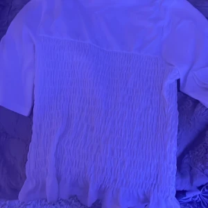 Vit trendig blus med smock💗💗 - Hola! Säljer min skitsnygga topp från Hm med smockdetaljer, inte riktigt min stil därav att jag säljer den! Helt i nyskick aldrig använd💘.