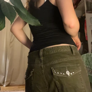 Olivgröna byxor med nitar - Snygga olivgröna byxor med raka ben och coola nitar på bakfickorna. Perfekta för en avslappnad stil med en touch av edge. De har en normal passform och är tillverkade i ett slitstarkt material. Storleken har försvunnit men förmodar att de är i storlek L då de sitter ganska pösigt på mig som har storlek M. De får en liten oversized look och nästan flare modell vilket jag personligen uppskattar.