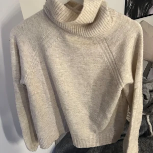 Beige polotröja från VILA - Mysig beige polotröja från VILA i storlek M. Tröjan har en ribbad polokrage och långa ärmar, perfekt för kyliga dagar. Aldrig använd
