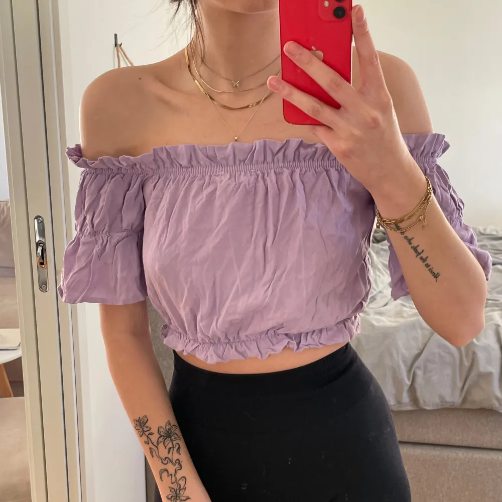 Säljer en söt lila offshoulder topp med korta ärmar och knytning framtill. Toppen har en elastisk kant vid axlar och midja för en bekväm passform. Den går att vända på beroende på hur du vill ha toppen!🌸✨. Yläosat.