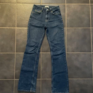 Blå bootcut jeans från Perfect Jeans - Snygga blå bootcut jeans från Perfect Jeans. De har en klassisk femficksdesign och en knappgylf. Perfekta för en avslappnad stil med en touch av retro.