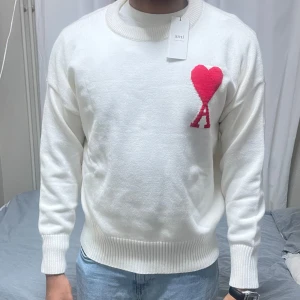 Vit tröja från Ami Alexandre Mattiussi - Säljer en stilren vit tröja från Ami Alexandre Mattiussi. Nytt skick. Modellen är 189 och 92 kg har på sig en storlek (Medium)