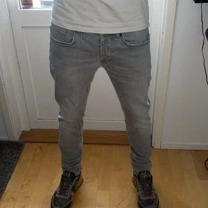 Grå Dondup jeans  - Säljer nu ett par feta och sällsynta gråa Dondup jeans. Storleken på jeansen är W33 men sitter som W31 eller W30. Modellen på Jensen är George. Har du några frågor så hör bara av dig. Priset är inte hugget i sten. 