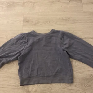 Grå tröja från KappAhl - Säljer en stilren grå tröja från KappAhl i storlek XS. Tröjan har långa ärmar och en enkel design som passar perfekt till vardags. Materialet känns mjukt och bekvämt.