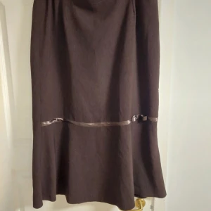 Lång kjol - Lång brun kjol, med detaljer o rosett, blixtlås i bak, typ storlek XL
