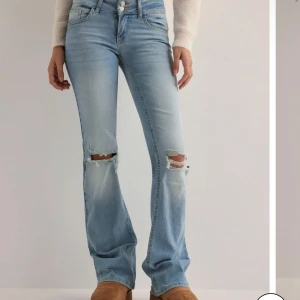 Ljusblå bootcut jeans med slitningar - Snygga ljusblå bootcut jeans med slitningar på knäna. De har en låg midja💕 vill även säga att jag sprättat upp dessa så de passar perfekt på mig mig som är 1,74