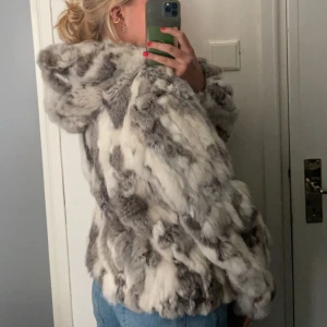 Mysig pälsjacka med huva - Säljer en varm och mysig pälsjacka med luva. Den är 100% kaninpäls med innerfoder i polyester. Märket är shebang men den är köpt second hand. Fint skick förutom en fläck i innerfodret!
