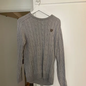Lexington kabelstickad tröja - Säljer nu min lexington kabelstickade tröja i storlek L men sitter som M ljusgrå färg kond 10/10 aldrig använd