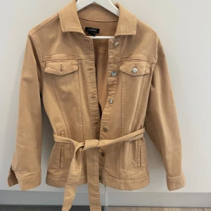 Jeansjacka från Lindex  - Jeansjacka från Lindex, använd fåtal gånger. Strl xs men skulle snarare säga strl s. Bälte i midjan som går att ta bort. Kan skicka mot fraktkostnad eller mötas upp i centrala Linköping 🥰(varan ligger ute på vinted också) 