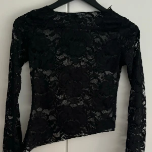 Svart spetströja  - En svart spetströja som är lite sne skuren ner till. Tröjan är aldrig använd 