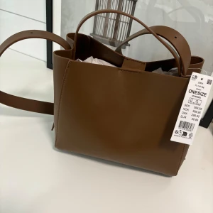 Brun nu väska från ginatricot - Säljer en helt ny väska från Ginatricot med lappar kvar som blivit ståendes i garderoben, ( nypris 399;-)  säljer den för 300;- 