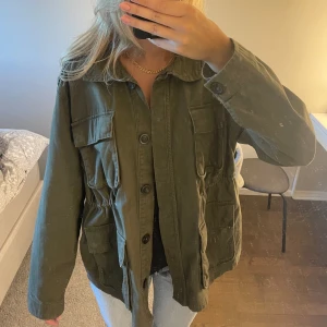 Grön jeansjacka  - Så fin o välvårdad grön jeansjacka från Kappahl💕 jackan är i storlek M och är perfekt i passformen enligt mig!! Jackan stängs med knappar, har en dragsko i midjan samt 4 riktiga fickor fram. Perfekt jacka till hösten🫶🏻🫶🏻