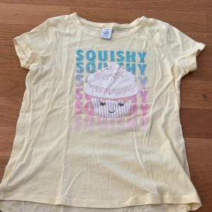 T-shirt - En t-shirt med tryck där det står squishy med en muffin i mitten lite skrynklig så jag har satt ned t-shirten på billigare pris😊