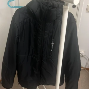 Svart jacka från Sail Racing - Säljer en svart jacka från Sail Racing i storlek Large. Jackan är vind- och vattentät med andningsfunktion, perfekt för höst och vinter. Den har en dragkedja framtill och en huva för extra skydd mot väder och vind. Tillverkad med återvunnet material och har en stilren design.