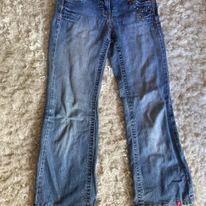 Blå jeansbyxor med detaljer - Säljer ett par snygga blå jeans.                        Forfarande i bra skick!💕 