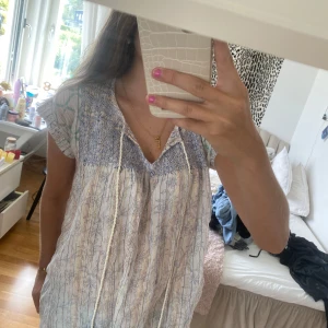 Vit och blå klänning från Rachel Roy - Säljer en superfin blus från Rachel Roy. Den har ett vackert mönster och är perfekt för sommaren. Blusen är i storlek S och har korta ärmar. Den är tillverkad i ett lätt och bekvämt material, perfekt för varma dagar. Köp den nu eller ge ett bud! 💙