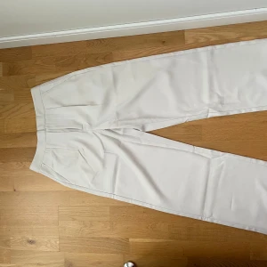 KrämVita kostymbyxor  - Krämvita kostymbyxor ifrån Lager 157 i storlek S. Byxorna är helt oanvända o väldigt fint skick. Två fickor fram och en bak. Säljs för 100+frakt