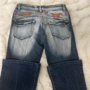 Byxor med fjärilar  - Säljer dessa låg midjade jeans i storlek S. Jag har storlek XS och XXS och byxorna är ganska stora på mig vid midjan. Midjemåttet är 35 cm rakt över och innerbenslängd 68 cm.