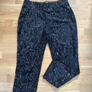 Glitterbyxor - Ett par svarta paljettbyxor från mango har använts ett fåtal gånger. Är små i storleken!