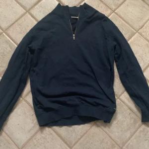 Mörkblå halv zip  - Säljer en mörkblå tröja från Kappahl i storlek 158/164. Tröjan har en dragkedja vid halsen och är långärmad. Perfekt för höst och vinter! 🧥