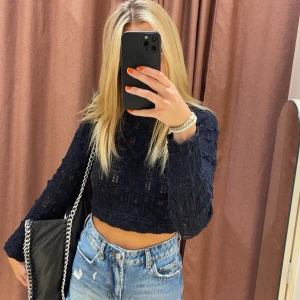 Svart spets topp med öppen rygg - Säljer en snygg svart virkad topp i. Har en öppen rygg. Säljer då den knappt är använd.