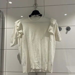 Vit topp med volanger - Vit topp med volanger, super fin, helt oanvänd 