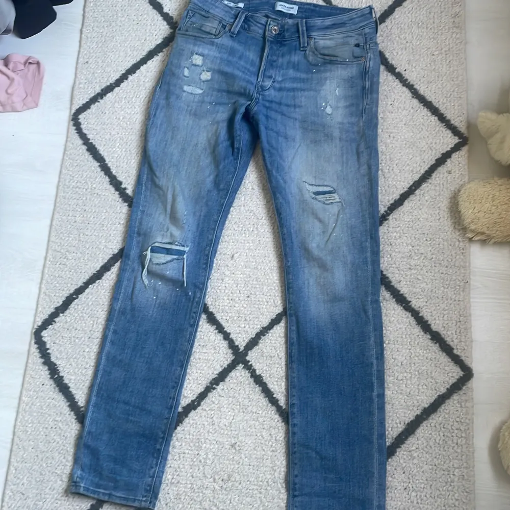 Säljer ett par blå jeans med slitningar på framsidan. svårtagen modell från Jack and Jones. Jeans & Byxor.