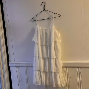 Kort vit volang klänning från vila - Kort vit volang klänning från vila bara använts en gång och har ändringsbara band! Väldigt skönt material och fin💐