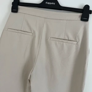 Beiga kostymbyxor - Kostymbyxor från H&M i stl. 36. Bra skick!