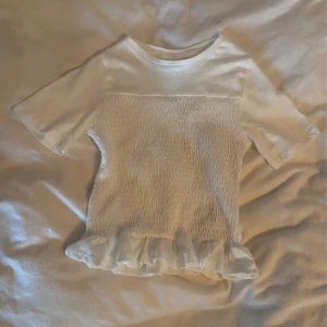 Eftertraktad smockad topp vit - En jättefin eftertraktad smockad topp från H&M. Den är slutsåld på hemsidan, står att den är XS men jag skulle uppskatta den som en XS/XXS  Först till kvarn!💕
