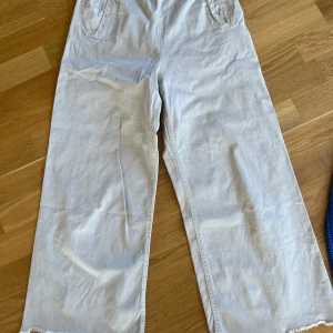 Byxor  - Sköna byxor i begie färg. Vida ben med dragkedja i sidan. Mycket bra skick!