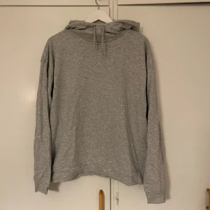 Grå hoodie - Säljer en enkel och bekväm grå hoodie. Perfekt för vardagsbruk med en avslappnad passform. Den har en klassisk huva med dragsko och långa ärmar. Perfekt för höst och vinter!
