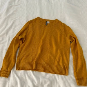 Gul stickad tröja från H&M Divided - Säljer en gul stickad tröja från H&M Divided. Tröjan har långa ärmar och en ribbad kant vid ärmslut och nederkant. 