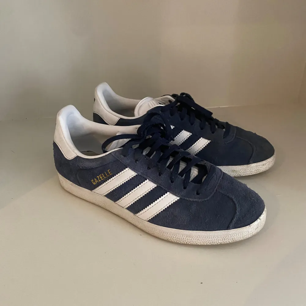 Säljer ett par supertrendiga mörkblå Adidas Gazelle skor i storlek 38. Så snygga till hösten och lätta att styla! 💙💙. Skor.