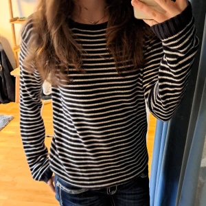 Randig stickad tröja - Söt randig stickad tröja köpt secondhand men bara använt ett fåtal gånger. Ganska bra skick inga hål eller fläckar. Basic och passar till allt. Mörkblå/svart och vit randig.