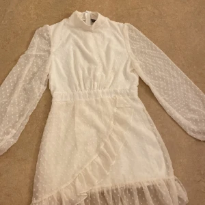 Vit prickig klänning med volangdetaljer - Charmig vit klänning med prickigt mönster och volangdetaljer. Har bara använt den 1 gång, passar för storlek xs och s! ❤️❤️🫶🏼