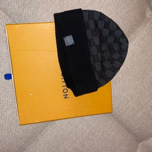 Svart Louis Vuitton mössa.  - Ursäkta dålig bild, vid intresse kan jag skicka fler bilder. 