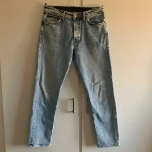 Ljusblå jeans från Jack & Jones - Säljer ett par ljusblå jeans från Jack & Jones i modellen Loose/Chris. De har en klassisk femficksdesign och knappgylf. Perfekta för en avslappnad stil.