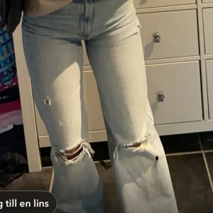 Ljusa jeans med slitningar - Säljer ett par ljusa jeans med slitningar på knäna. De har en hög midja och en bootcut-stil i mycket bra skick 