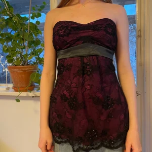 Axelbandslös topp - Vinröd/rosa axelbandslös topp med svart spetsöverdrag och satinband i midjan som knyts baktill. 🎀
